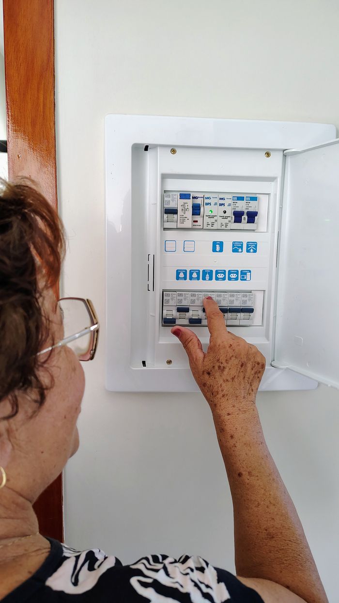 Mastering the First Impression: Your intriguing post title goes here A woman interacting with an electrical control panel inside a house, showing hands-on operation.