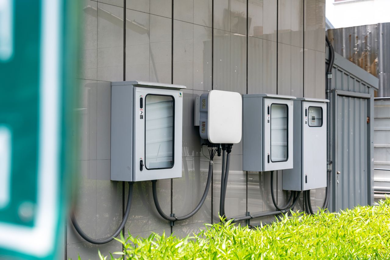 brand-02 Close-up of outdoor electrical utility boxes with cabling on a building exterior.